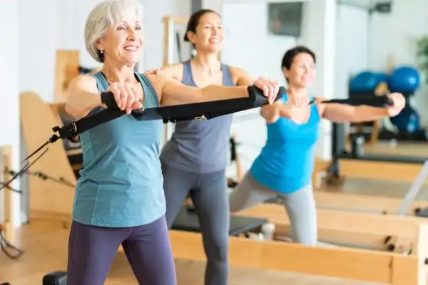 Toning Arms After 60: Empowering Womens Fitness Through Effective Weight Training 2 older woman doing weight training Billericay and resistance in the gym to tone upper arms