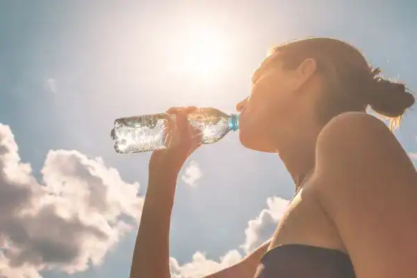 Hydration: The Secret Ingredient for a Toned Stomach and Enhanced Fitness 3 Image of woman drinking water to hydrate Billericay after run.