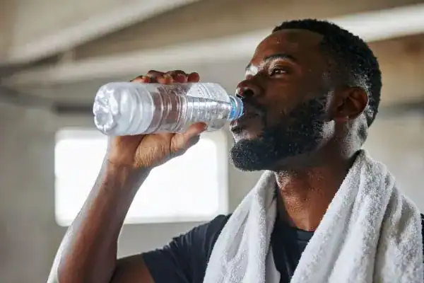 Hydration: The Secret Ingredient for a Toned Stomach and Enhanced Fitness 1 Image of man drinking water to improve hydration Billericay after work out.